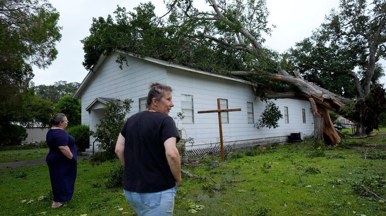 Ann McCauley, right, examines the damage at Bethel Church after...