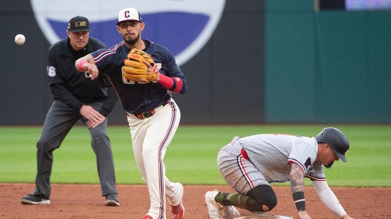 Cleveland Guardians' Gabriel Arias, front left, forces out Minnesota Twins'...