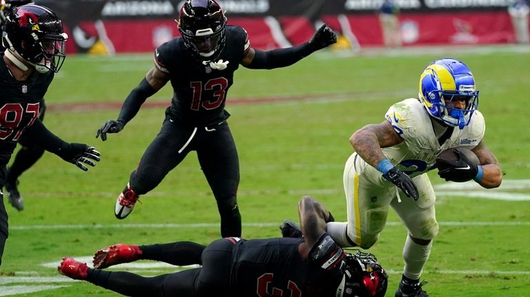 Los Angeles Rams running back Kyren Williams, right, tries to...