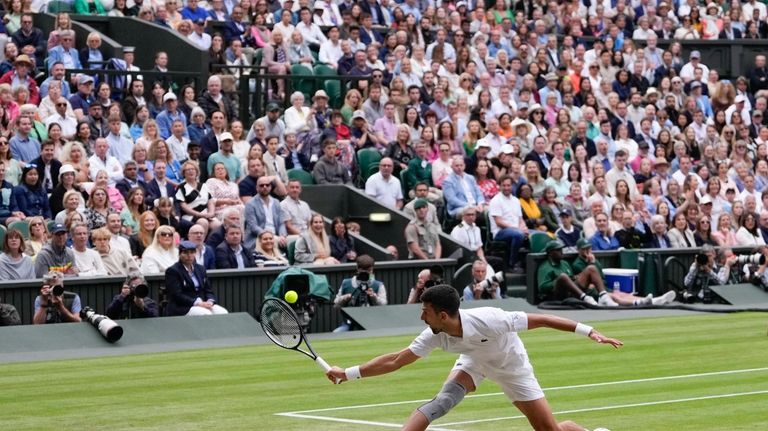 Novak Djokovic of Serbia plays a backhand return to Lorenzo...