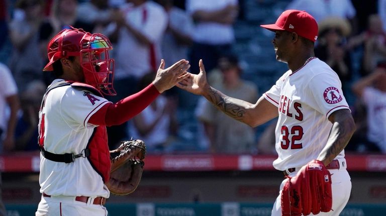 Angels catcher Kurt Suzuki, left, and relief pitcher Raisel Iglesias...