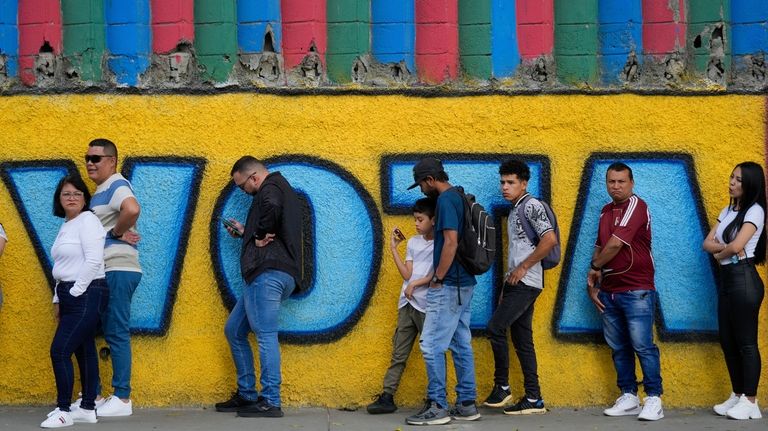 Voters line up outside a polling station during presidential elections...