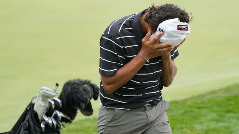 Charlie Woods walks off the 18th green during the first...