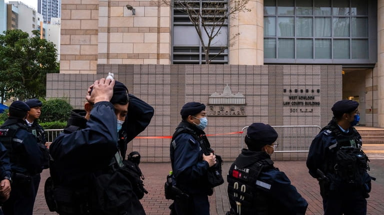 Police officers patrol outside the West Kowloon Magistrates' Courts, where...