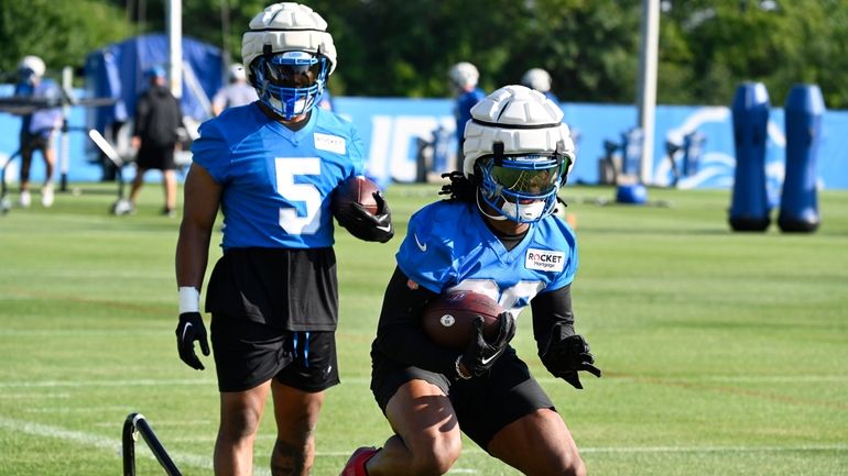 Detroit Lions running back Jahmyr Gibbs, front, runs a drill...