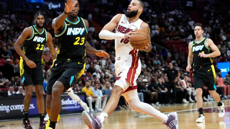 Miami Heat forward Caleb Martin (16) drives to the basket...