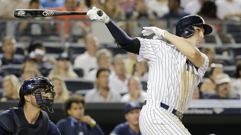 New York Yankees' Greg Bird follows through and watches his...