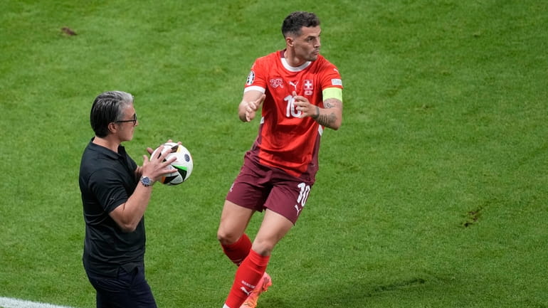 Switzerland's head coach Murat Yakin holds a ball ahead of...