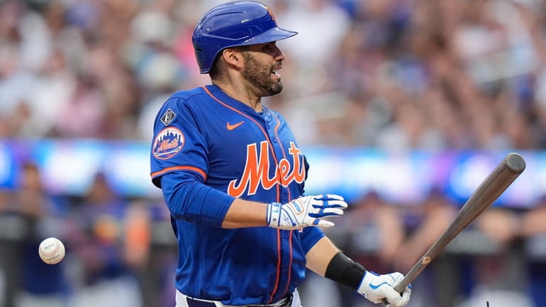 The Mets' J.D. Martinez reacts after getting hit by a...