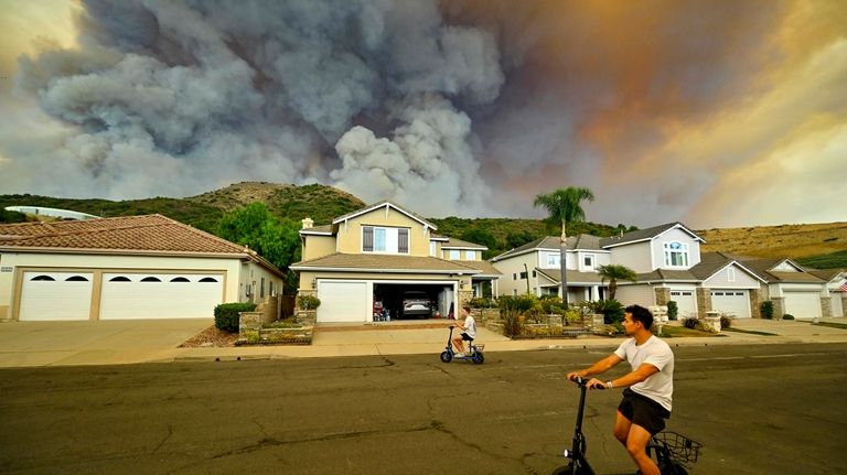 Smoke from the Airport Fire rises behind Meander Lane in...