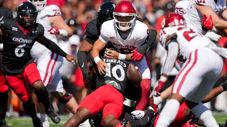 Oklahoma quarterback Dillon Gabriel, center, fumbles the ball as he...