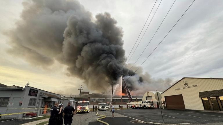 Firefigthers battle a blaze at a warehouse in York, Pa.,...