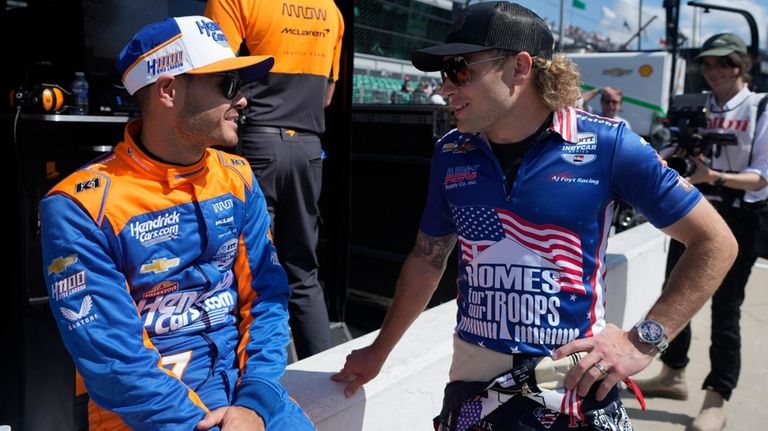 Kyle Larson, left, talks with Santino Ferrucci during qualifications for...