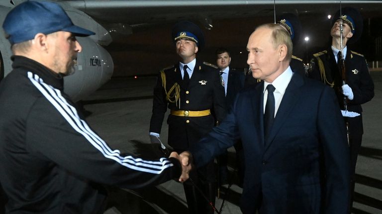 Russian President Vladimir Putin greets Vadim Krasikov upon arrival of...