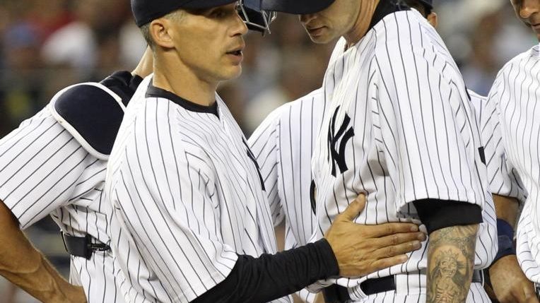 New York Yankees manager Joe Girardi, left, takes starting pitcher...