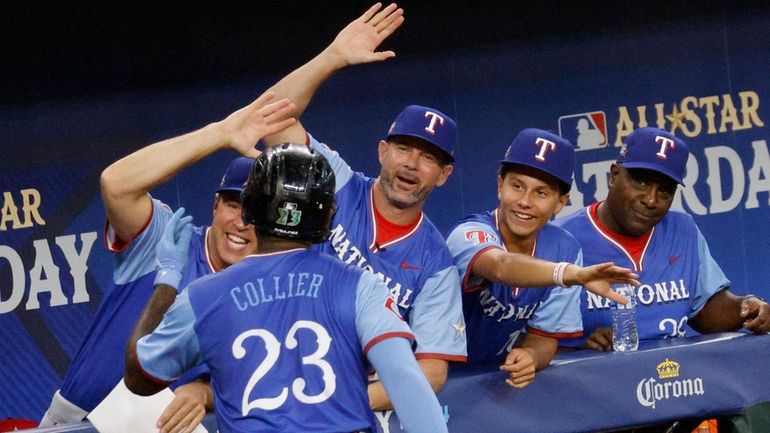 National League's Cam Collier (23) gets high-fives from former Texas...