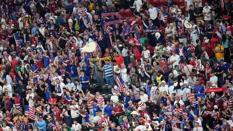 Fans from the United States cheer for their team during...