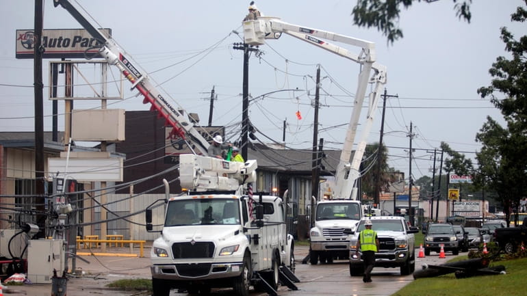 Utility crews work to restore electricity in Houston, Thursday, July...