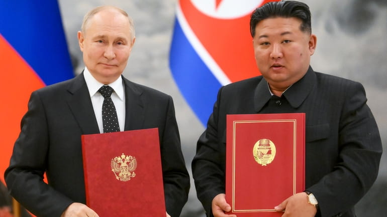 Russian President Vladimir Putin, left, and North Korea's leader Kim...