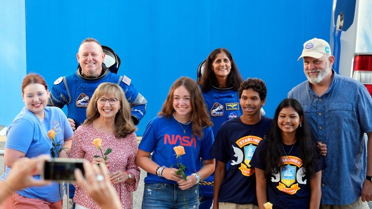 NASA astronauts Butch Wilmore, background left, and Suni Williams, background...