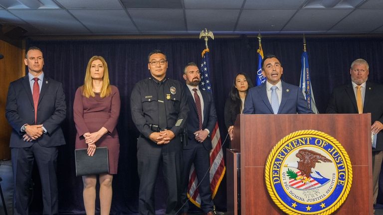 United States Attorney Martin Estrada, at podium, is joined by...