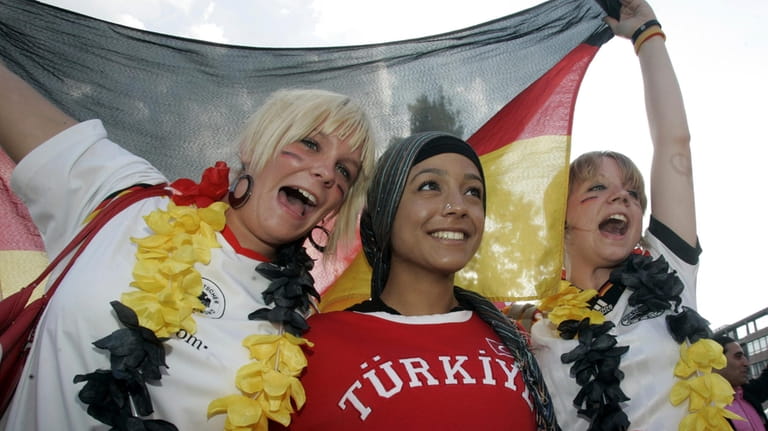 German and Turkish fans celebrate at the KoelnArena-Dome prior to...