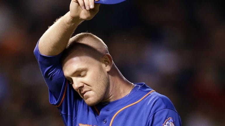 Mets relief pitcher Vic Black reacts as he wipes his...