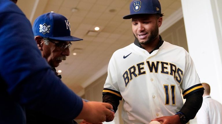 Milwaukee Brewers outfielder Jackson Chourio signs autographs following a news...