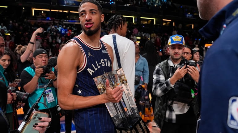 Indiana Pacers guard Tyrese Haliburton (0) carries the Championship trophy...