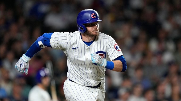 Chicago Cubs' Ian Happ watches his home run off Milwaukee...