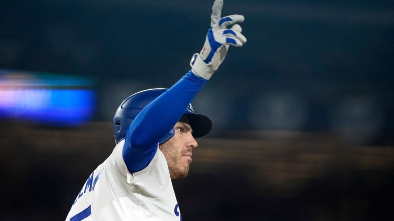 Los Angeles Dodgers' Freddie Freeman gestures as he rounds first...