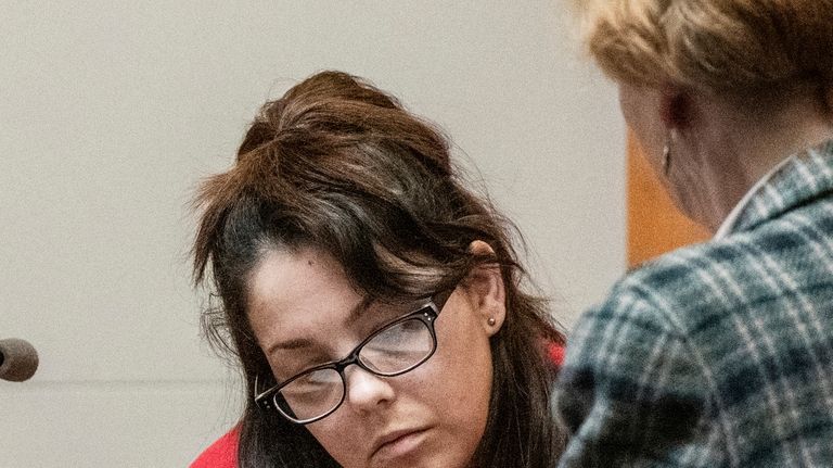 Kayla Montgomery reviews documents while testifying during the trial of...