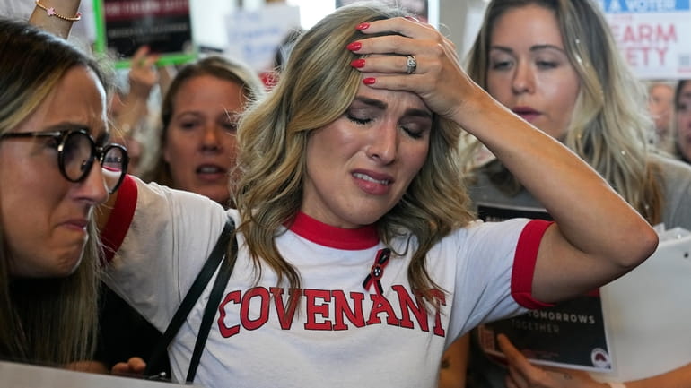 Covenant School parent Mary Joyce is overcome with emotion as...