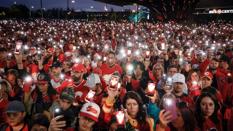 Fans attend a vigil for former Calgary Flames player Johnny...