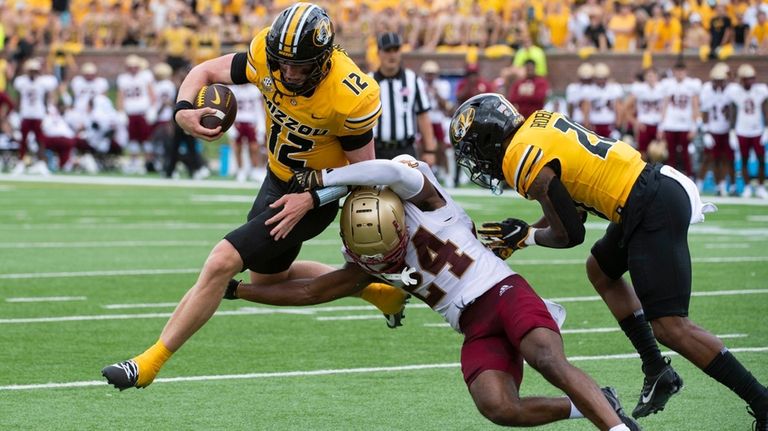 Missouri quarterback Brady Cook (12) jumps over Boston College cornerback...