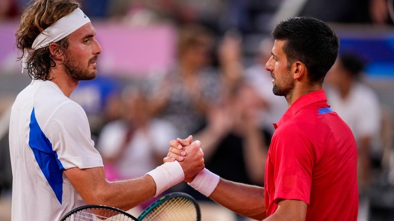 Serbia's Novak Djokovic, right, shakes hads with Stefanos Tsitsipas of...