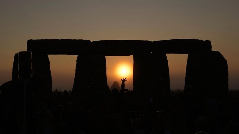 Revelers gather at the ancient stone circle Stonehenge to celebrate...