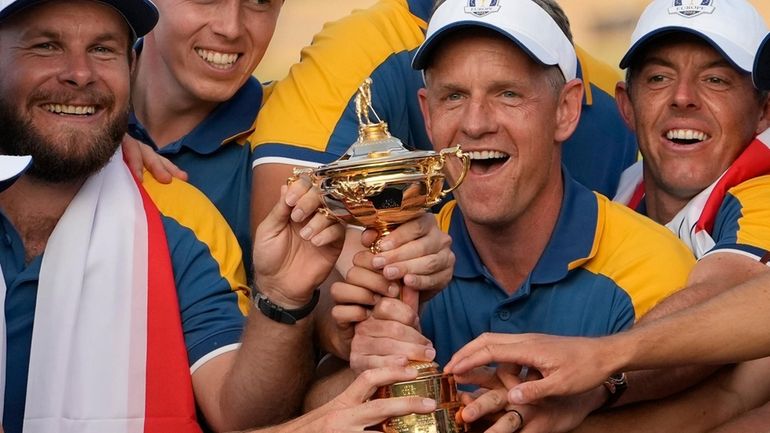 Europe's Team Captain Luke Donald, centre, and team members lift...