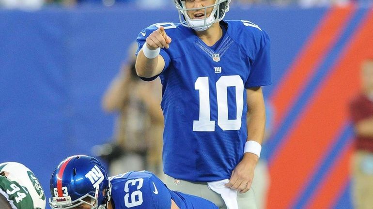 Eli Manning points to the defense during the first half...