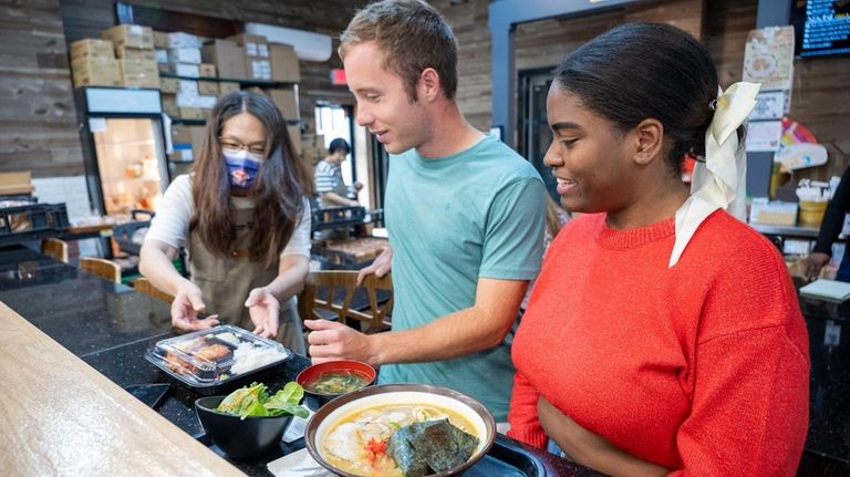 David Moral, 24, center, and Nathalia Riascos, 26, right, both of Westbury, have...