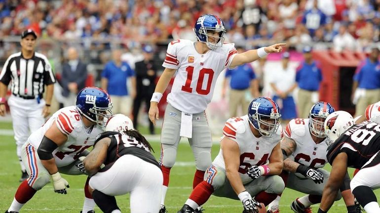 Eli Manning #10 of the New York Giants points at...