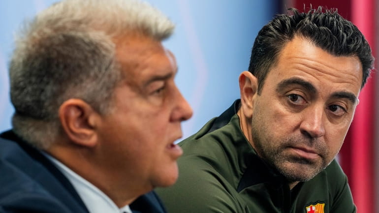 Barcelona's head coach Xavi Hernandez listens to Barcelona's president Joan...