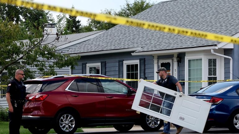 A Romeoville Police officer carries out a door from inside...