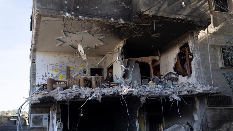 Palestinians inspect a destroyed house following an Israeli army operation,...