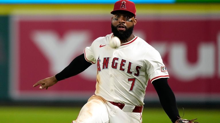 Los Angeles Angels right fielder Jo Adell fields a ball...