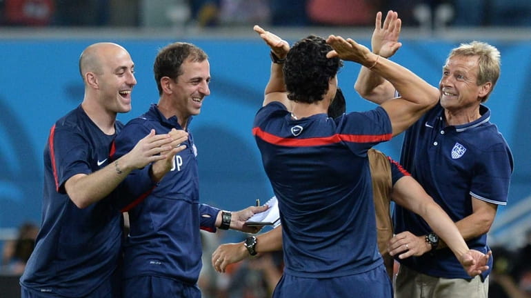 U.S. coach Juergen Klinsmann, right, celebrates with teammates during a...