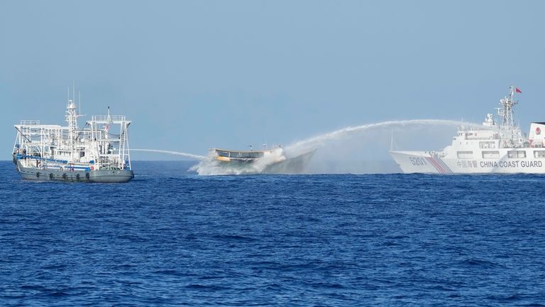 Philippine resupply vessel Unaizah May 4, center, is hit by...