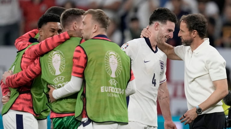 England's manager Gareth Southgate embraces England's Declan Rice at the...