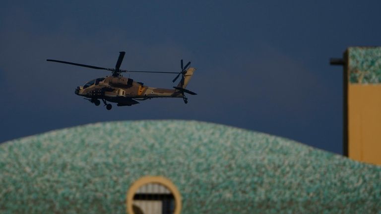 An Israeli Apache helicopter flies over an area in Israel,...