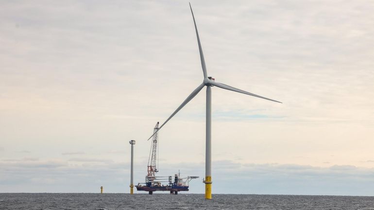 An operational wind turbine, along with one under construction behind...